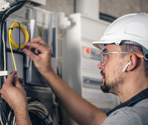 man electrical technician working switchboard with fuses